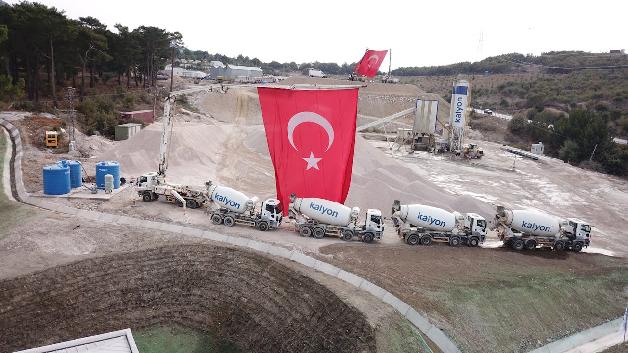Aerial shot of a construction site with cement trucks and Turkish flags in Çanakkale, Turkey.